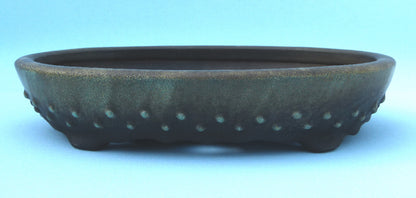Ceramic pot with textured surface on a light blue background