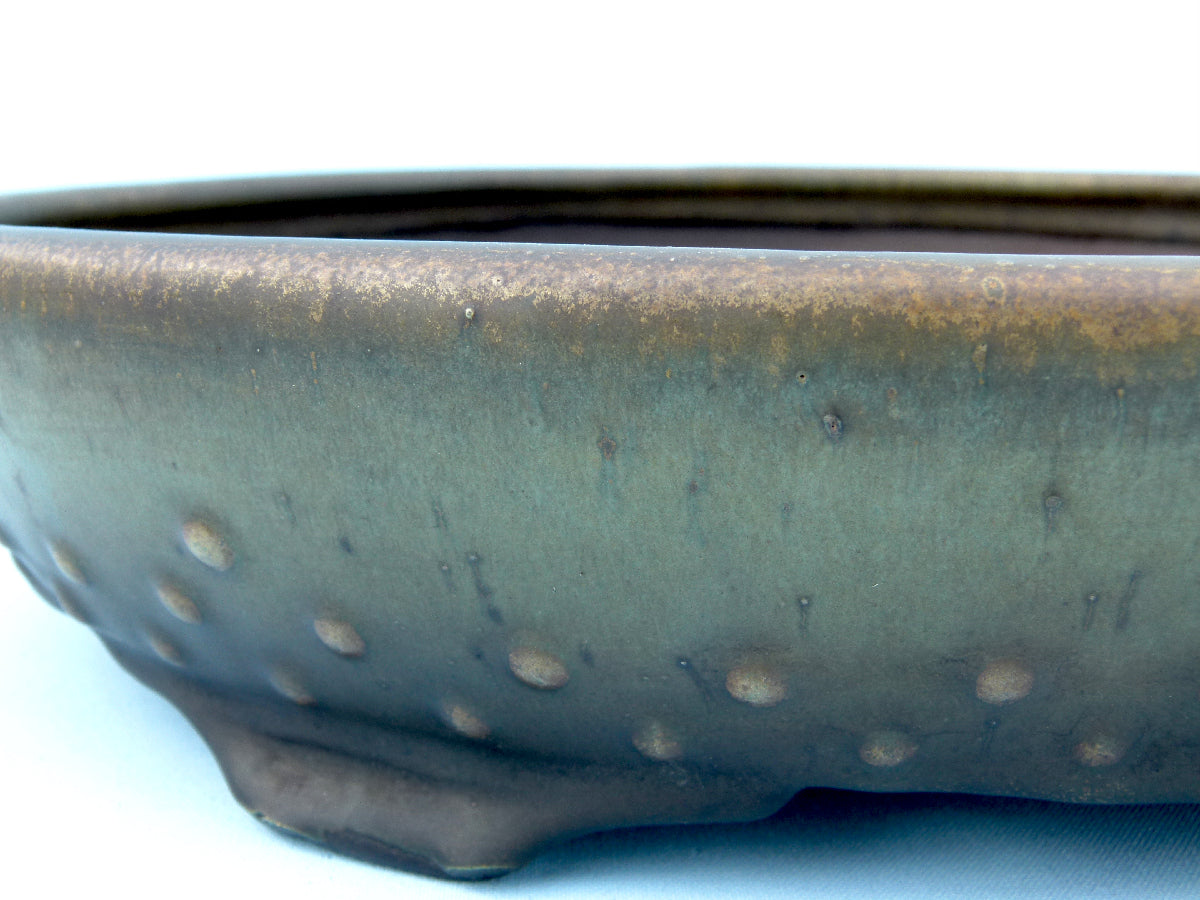 Close-up of a ceramic pot with a textured surface on a white background
