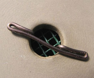 Ensure it is a close fit within the drainage hole. Push the legs just into the hole, put the mesh over from the inside and then pull the wire through.